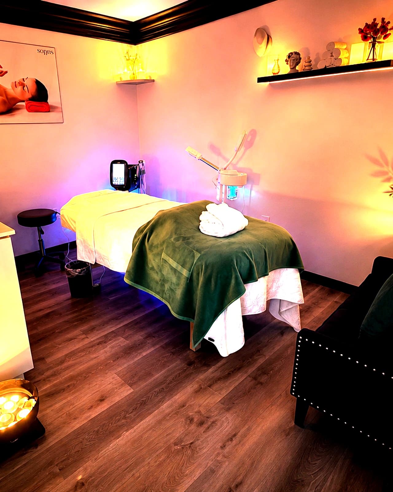 Private treatment room with a plush treatment bed and warm ambient lighting